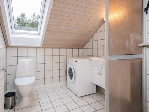 a bathroom with a toilet and a washing machine at 6 person holiday home in Rømø-By Traum in Sønderby