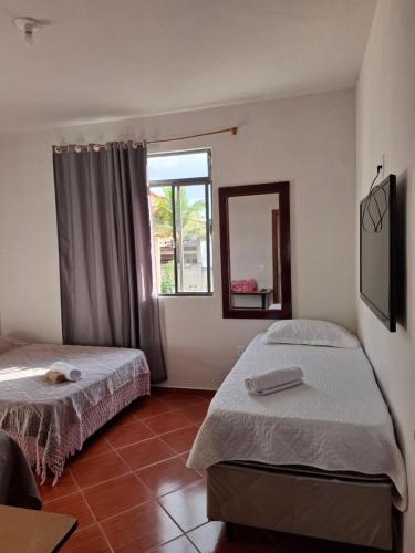 a bedroom with two beds and a window at Suite confort 02 in Contagem