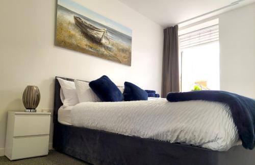 a bedroom with a bed with a painting on the wall at Airy flat is the heart of Northampton in Northampton