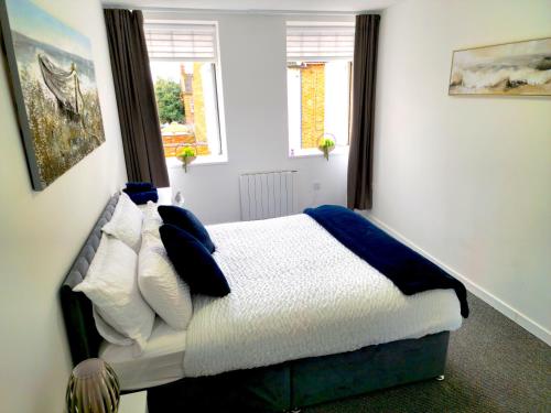 a bedroom with a bed with white and blue pillows at Airy flat is the heart of Northampton in Northampton