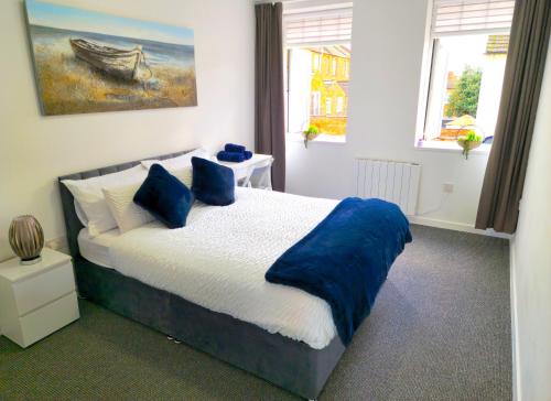 a bedroom with a bed with blue pillows at Airy flat is the heart of Northampton in Northampton