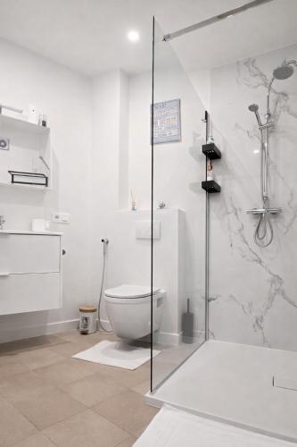 a white bathroom with a toilet and a shower at cozy studio Brussels airport in Steenokkerzeel