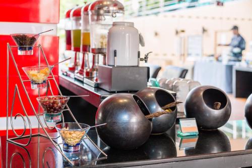 a counter with bowls and cups on top of it at Nova Platinum Hotel in Pattaya South