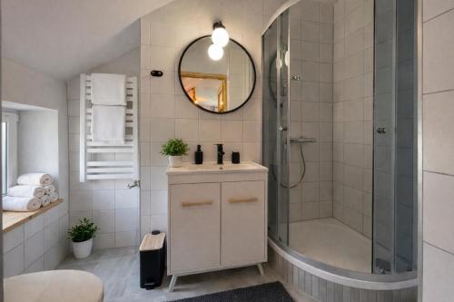 a bathroom with a shower and a sink and a mirror at apartamentwroznowiepl in Rożnów