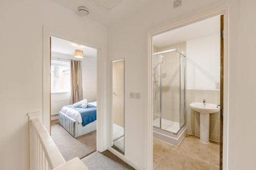 a bathroom with a bed and a sink and a mirror at Modern 2 Bedroom House in Cheshunt in Cheshunt