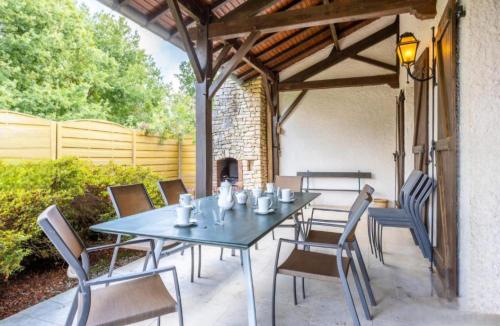 une table et des chaises sur une terrasse avec une cheminée dans l'établissement Gîte Nolan, à Saint-Mesmin