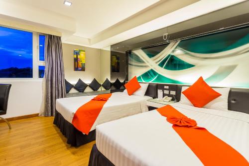 two beds in a room with a window at Nova Platinum Hotel in Pattaya South