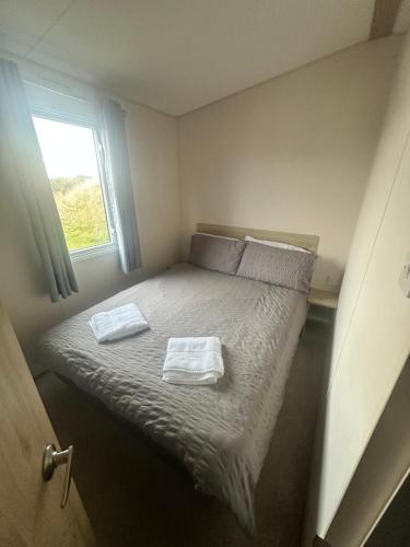 a small bedroom with a bed with two towels on it at Moonstone in Lossiemouth