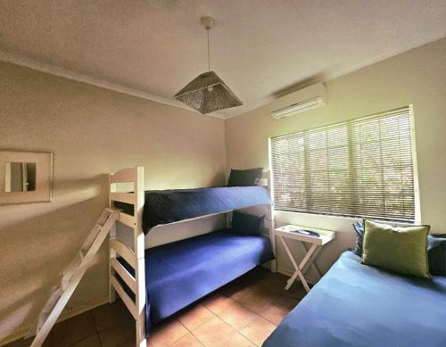 a bedroom with two bunk beds and a couch at Schuilhoek Farm House at Ngweni Private Game Farm in Hluhluwe