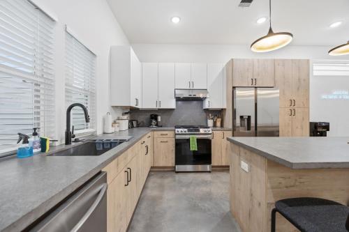 a kitchen with white cabinets and stainless steel appliances at The Right House @ East Downtown in Houston