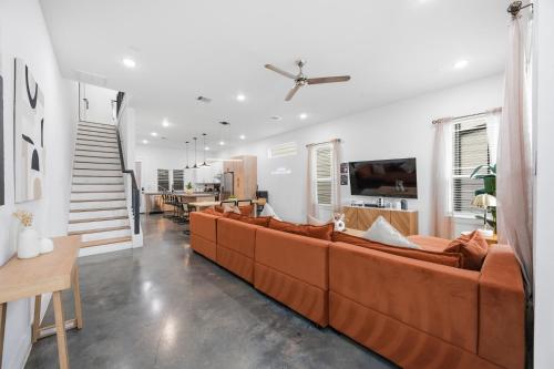 a living room with a brown couch and a table at The Right House @ East Downtown in Houston