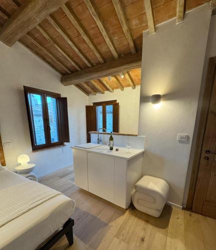 a bedroom with a bed and a bathroom with a sink at La casina del borgo - Monolocale Nettuno in Perugia