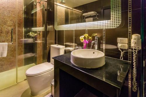 a bathroom with a sink and a toilet and a shower at Nova Platinum Hotel in Pattaya South