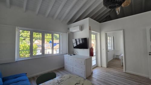 a living room with a tv and a couch at Vulcânica - Boutique Suites in Furnas São Miguel in Furnas