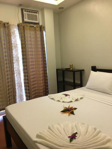 a bedroom with a bed with two star decorations on it at Seaslugs Travellers Inn in El Nido