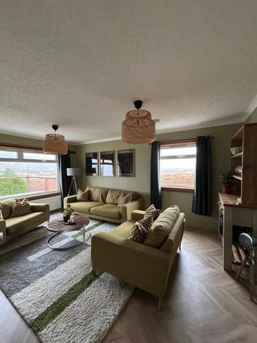 a living room with two couches and a rug at Hillview Portree Isle of Skye Self Catering House in Portree