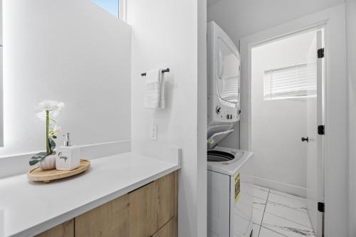 a white kitchen with a sink and a washing machine at The Right Studio @ East Downtown in Houston