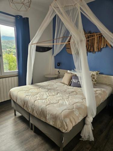 a bed with a canopy in a blue bedroom at VILLA VILLACOLLE in Procchio