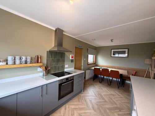a kitchen with a stove top oven next to a table at Hillview Portree Isle of Skye Self Catering House in Portree