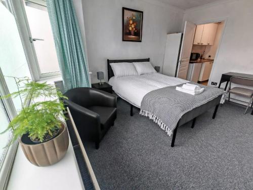 a hotel room with a bed and a chair at Lilac Studio - Self Contained One-Bed Studio Flat in Oxford
