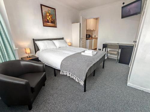 a bedroom with a bed and a chair and a desk at Lilac Studio - Self Contained One-Bed Studio Flat in Oxford