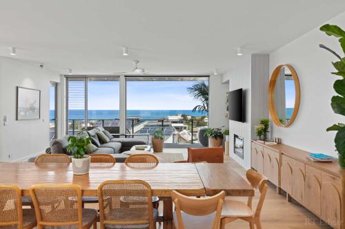 a living room with a dining table and a view of the ocean at Seaside Luxury - Panoramic Views in Heart of Town in Ocean Grove