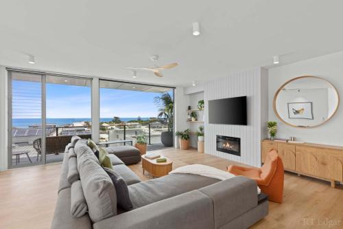 a living room with a couch and a fireplace at Seaside Luxury - Panoramic Views in Heart of Town in Ocean Grove