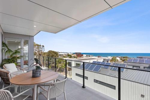 a balcony with a table and chairs and the ocean at Seaside Luxury - Panoramic Views in Heart of Town in Ocean Grove