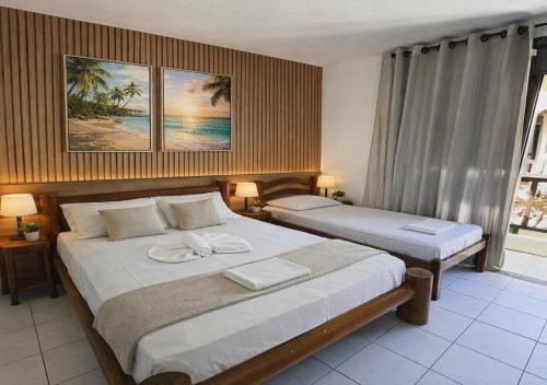 a bedroom with two beds and a window at Mar Azul Flats com Piscina, Cozinha mais estacionamento em Ponta N in Natal