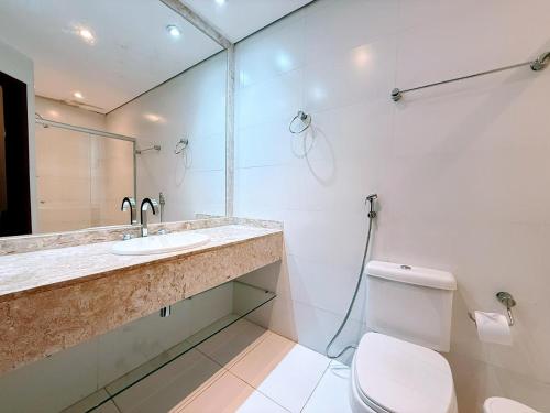 a white bathroom with a sink and a toilet at Luxo no Castelo - Duplex Premium com Lazer total e Piscina aquecida in Campos do Jordão