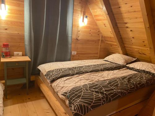 a bedroom with two beds in a wooden cabin at Brvnara Zoja - Zlatar in Prorečane