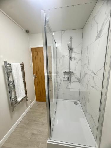 a bathroom with a shower with a glass door at Cornish coastal escape in Bude in Bude