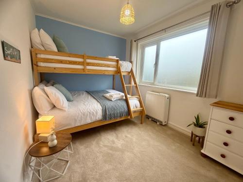a bedroom with a bunk bed and a window at Cornish coastal escape in Bude in Bude