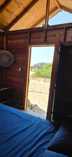 a bedroom with a bed and a view of the beach at Chacahua Cabañas LAUD in Guayabas