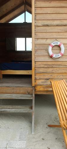 a wooden bunk bed with a lifesaver next to a bench at Chacahua Cabañas LAUD in Guayabas