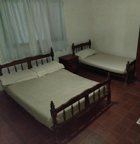 two beds sitting in a room withermottermottermott at Casona Estación Cabra Corral in Coronel Moldes