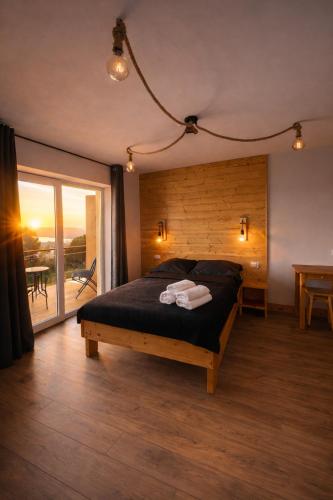 a bedroom with a bed with black sheets and a balcony at apartamentwroznowiepl in Rożnów