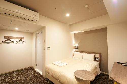 a hotel room with a bed and a table at Sotetsu Fresa Inn Ginza-Nanachome in Tokyo