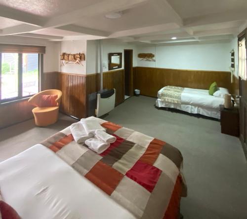 a hotel room with two beds and a bedvisor at Hostal Amerindia in Puerto Natales