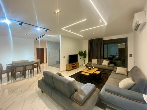 a living room with couches and a dining room at دار المكارم للشقق الفندقية الفاخره in Jerash