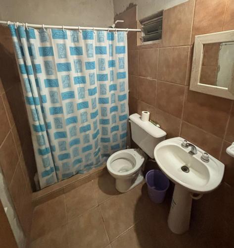 a bathroom with a toilet and a sink and a shower curtain at Lo de Celia in Chos Malal
