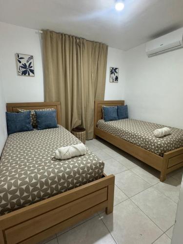 two beds sitting next to each other in a room at Estilo y comodidad a pasos de la playa in La Romana