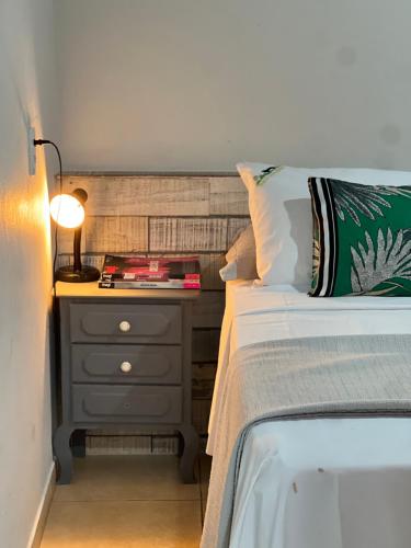 a bedroom with a bed and a nightstand with a lamp at Toca do Lobo in Pirenópolis