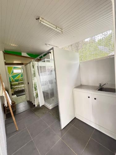 a kitchen with white cabinets and a sink and a window at Villa BEAUCI-TURLET in Goyave