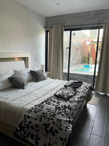 a bedroom with a bed and a large window at D&B apartments in Lo de Marcos