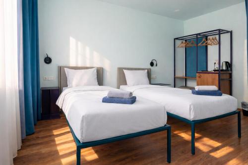 two beds in a room with white sheets at Das Schreder Hotel - Munich Free Parking in Munich