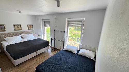 a bedroom with two beds and a window at Villa AMULET - Spacious 3BR Villa near Postojna Cave in Postojna