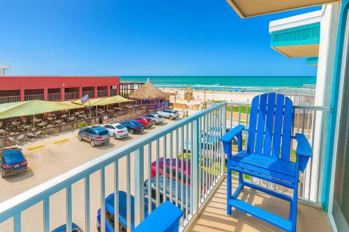a blue chair sitting on a balcony overlooking the beach at La Internacional 313 home in South Padre Island