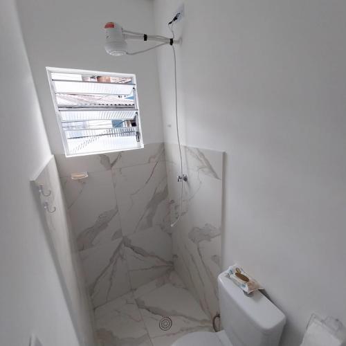 a white bathroom with a shower and a toilet at Ap Interlagos apoia adversidade in São Paulo