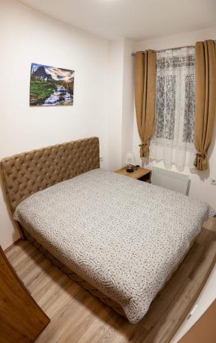 a bedroom with a large bed in a room at Aqua Lux Apartman in Jagodina